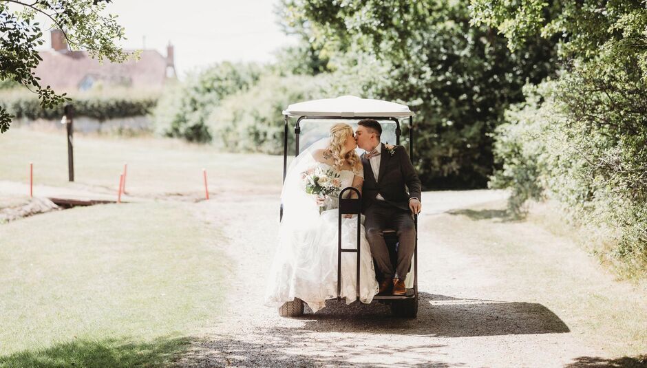 Newlyweds pose for photos on a golf buggy at Fareham Wedding Venue Skylark Country Club